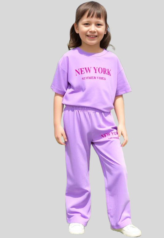 Young girl wearing a relaxed, oversized t-shirt with wide-leg loose fit trousers, styled for comfort and ease.